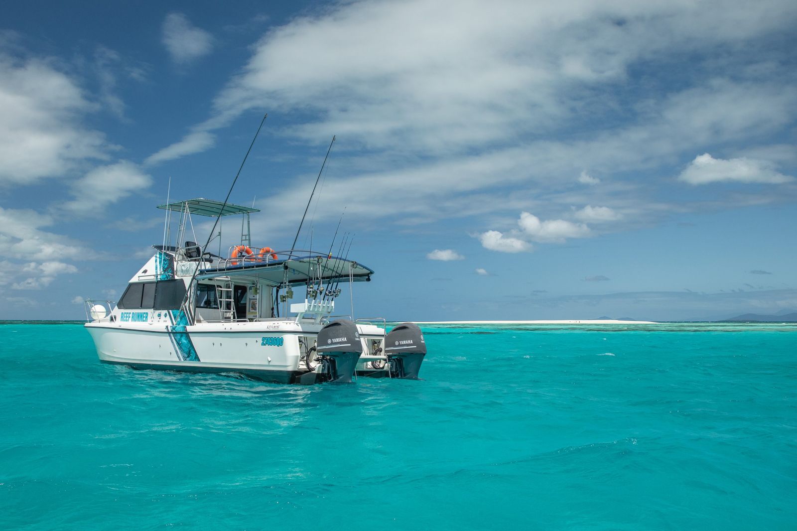 A charter fishing boat on clear turquoise water