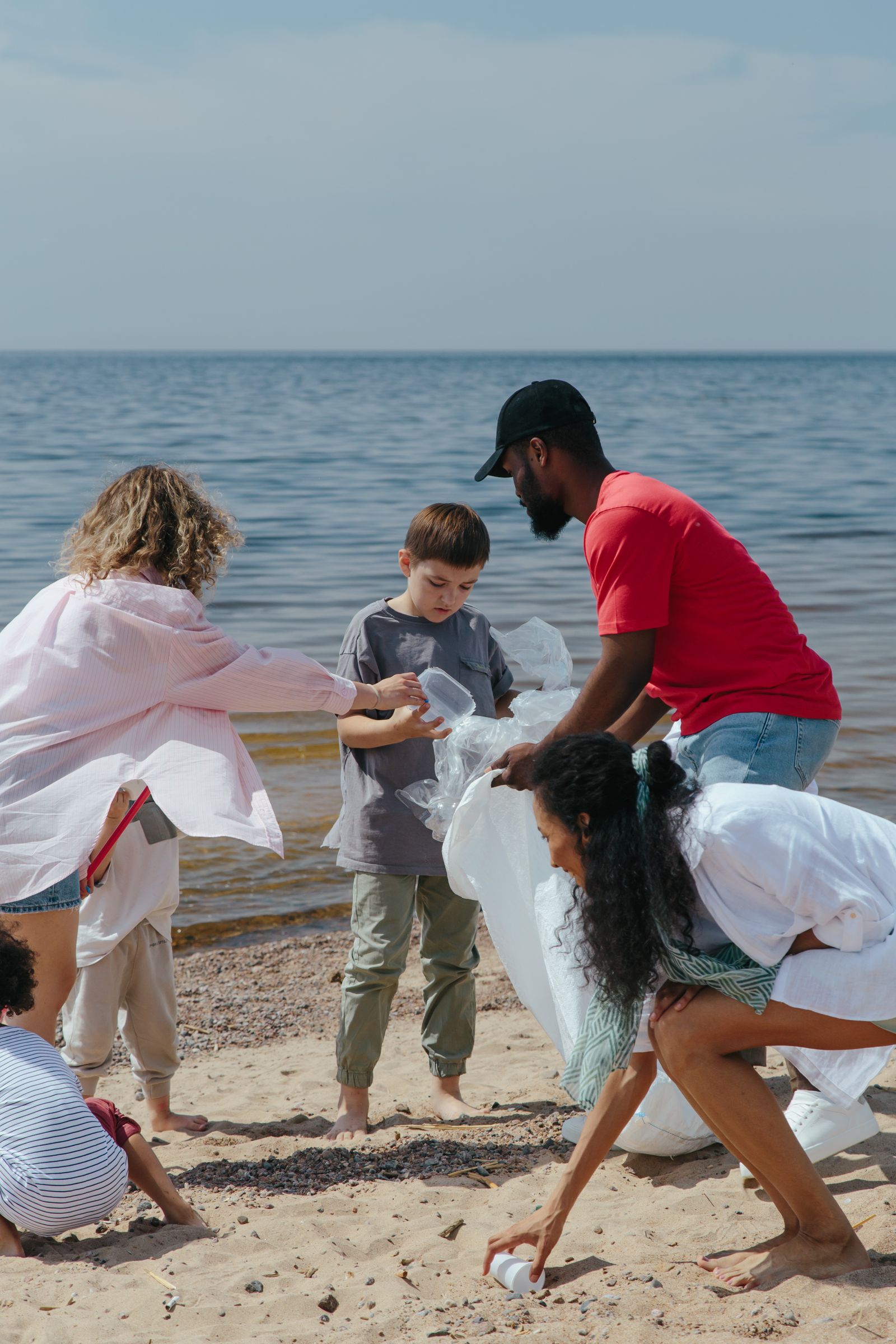 A family collecting litter together at the water's edge